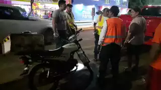 Un motociclista quedó con todo y unidad debajo de un vehículo que estaba estacionado