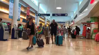 Los pasillos del aeropuerto de Cancún se pudieron ver repletos de gente que apurada hacia su check in