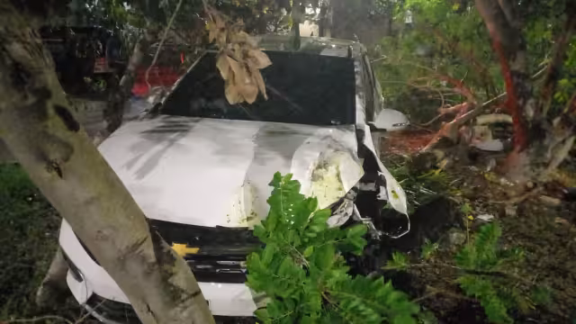 El Aveo blanco quedó muy dañado y entre la maleza de los árboles.