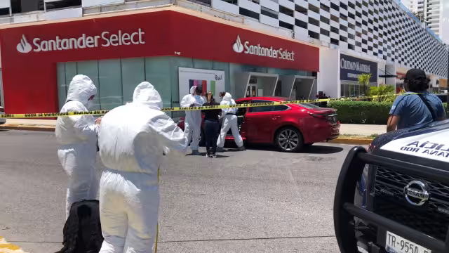 El automóvil permanece en la zona del ataque armado en Cancún, mientras Servicios Periciales recaban evidencias del hecho