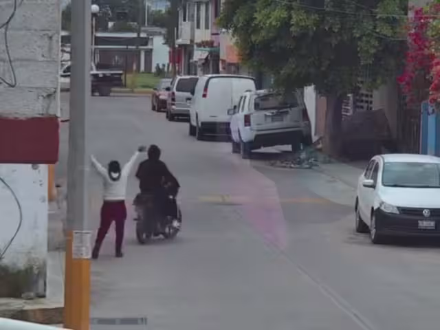Mujer siendo asaltada por un individuo en motocicleta en la calle Mártires, es ignorada por policías de Tultepec.