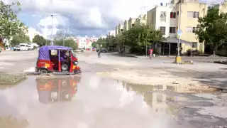 Proliferan los baches en Paseos del Mar en Cancún; los rellenan con grava y arena