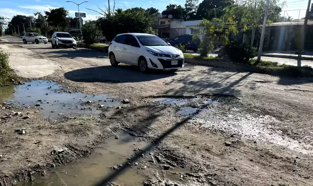 Motociclistas circulan sobre banquetas por mal estado de la avenida en Ucum