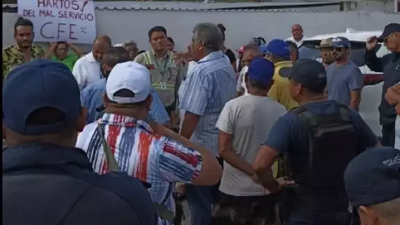 Se logra apreciar a los ciudadanos con cartulinas con mensajes escritos "Hartos del mal servicio de la CFE"