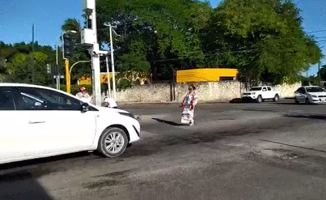 La joven espera que el semáforo se coloque en rojo para poner comenzar a bailar