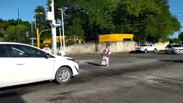 La joven espera que el semáforo se coloque en rojo para poner comenzar a bailar