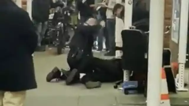 Momento en que el oficial ataca al indigente en el suelo