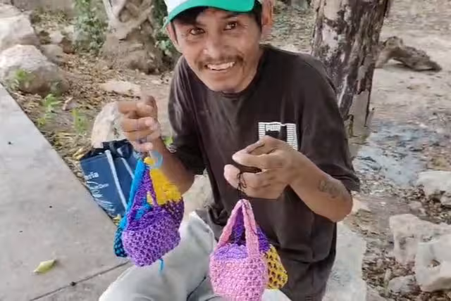 Bajo un árbol y con sus manualidades, artesano lucha por obtener el sustento diario