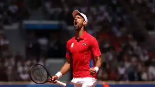 Novak Djokovic celebrando su victoria y medalla de oro olímpica tras vencer a Carlos Alcaraz en la final de tenis de París 2024.