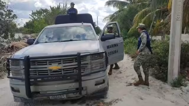 Agentes federales atienden el reporte de turistas frente a un hotel, en la playa de Telchac Puerto
