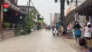 Habitantes y turistas, caminan entre el agua, buscando zonas donde el agua aun no llegue par poder transitar sin riesgo