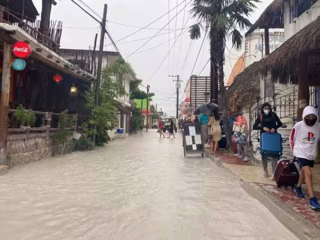 Habitantes y turistas, caminan entre el agua, buscando zonas donde el agua aun no llegue par poder transitar sin riesgo
