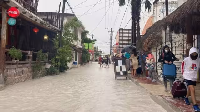 Habitantes y turistas, caminan entre el agua, buscando zonas donde el agua aun no llegue par poder transitar sin riesgo
