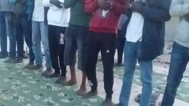 migrantes rezando antes de subierse a una precaria embarcación para tratar de llegar de Libia a Europa