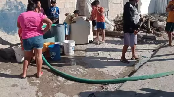 Los residentes de estas zonas tienen que llenar cubetas desde las pipas de agua Los residentes de estas zonas tienen que llenar cubetas desde las pipas de agua