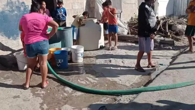 Los residentes de estas zonas tienen que llenar cubetas desde las pipas de agua
