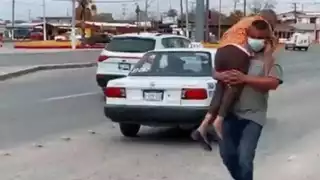 Un hombre carga a su mamá para llevarla a vacunar contra el COVID-19