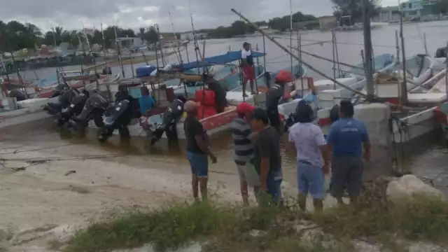 Los hombres trabajan  en equipo para sacar de agua a las naves marítimas. Foto: José Luis Jiménez Mendoza