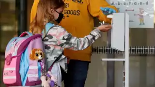 Niña tomando una porción de gel sanitario