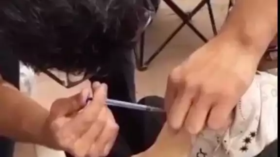Momento en el que se ve al enfermero inyectar a la mujer Momento en el que se ve al enfermero inyectar a la mujer