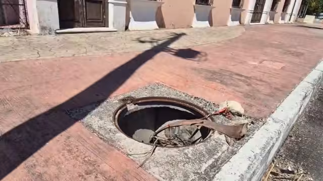 Un registro sin tapa de la CFE representa un peligro para peatones en el malecón de Champotón.