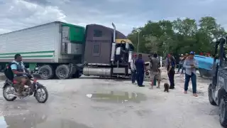 La llanta de un pesado tractocamión se hundió en una calle de arena húmeda