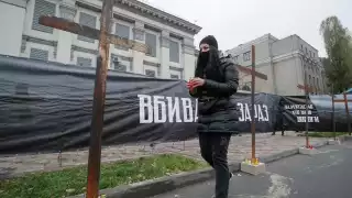 Un activista ucraniano se disponía a colocar una vela frente a la embajada de Rusia en Kiev.  EFE/EPA/SERGEY DOLZHENKO
