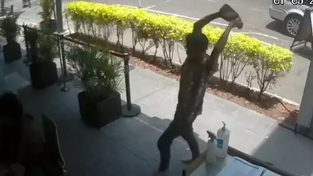 Momento en el que un hombre lanza un tabique al joven en restaurante de la CDMX