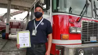 Hector Pimentel posa con su reconocimiento de lealtad y sacrificio por el rescate de Spike y Spay