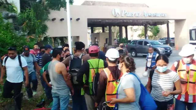 Lo trabajadores esperan en la entrada para ir a sus labores