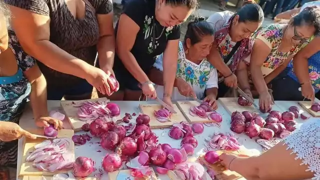 Integrantes de un gremio participan en el Dzan Cebolla, previo al inicio de las fiestas del pueblo