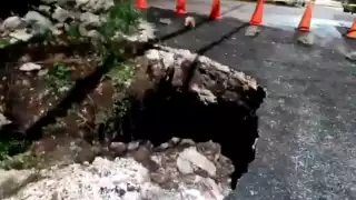 El hundimiento de la carretera provocó que un poste de la Comisión Federal de Electricidad se ladeara y tensara los cables de energía