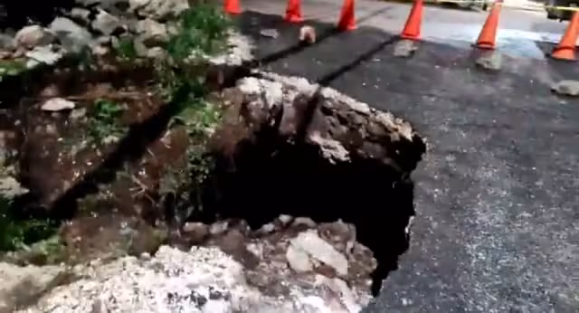El hundimiento de la carretera provocó que un poste de la Comisión Federal de Electricidad se ladeara y tensara los cables de energía