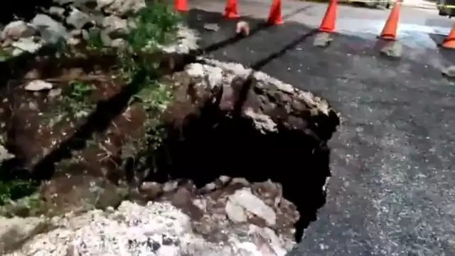 El hundimiento de la carretera provocó que un poste de la Comisión Federal de Electricidad se ladeara y tensara los cables de energía