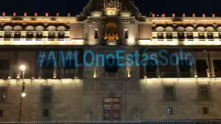 la fachada de Palacio Nacional lució iluminada con la proyección del mensaje #AMLOnoEstásSolo con letras azules.