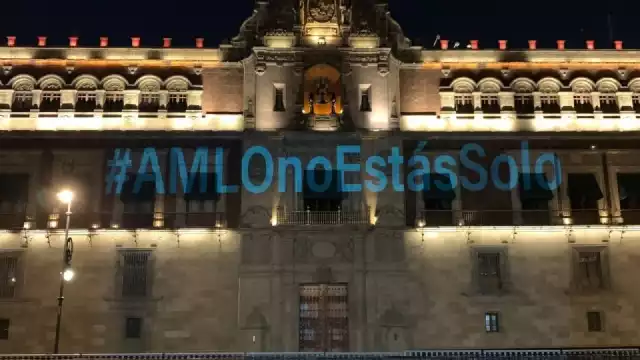la fachada de Palacio Nacional lució iluminada con la proyección del mensaje #AMLOnoEstásSolo con letras azules.