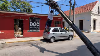 Trabajador de Telmex queda suspendido entre cables tras desplome de postes