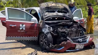 Taxi Nissan Versa se incendia tras salir de una gasolinera. Presunto cortocircuito en el motor habría originado el fuego.