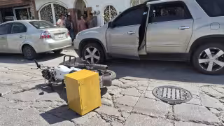 Una pareja de motociclistas se impactó contra la puerta de una GMC Acadia.