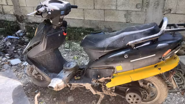 La motoneta color negro con amarillo quedó abandonada.