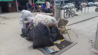 Bolsas con restos de comida, colchones y sábanas desechados en la vía pública