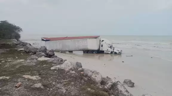 Un tráiler termina en la orilla del mar desdprendido de un accidente víal.