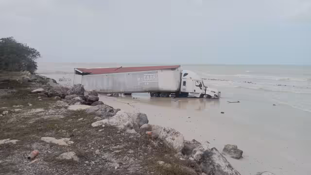 Un tráiler termina en la orilla del mar desdprendido de un accidente víal.