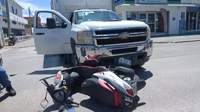 Mujer en motocicleta atropellada por camioneta de empresa de abarrotes.