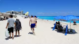 Turistas extranjeros aprovecharon las condiciones del día para caminar por la arena, mientras los nacionales llevaban alimentos y sus aguas para hidratarse.