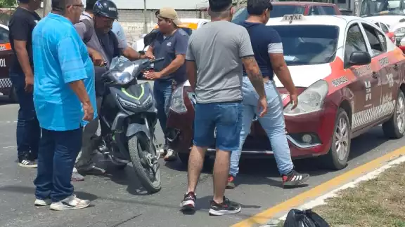 Un taxi Nissan rojo con blanco impactó por alcance a una motocicleta Italika negra con verde en la Avenida Solidaridad.
