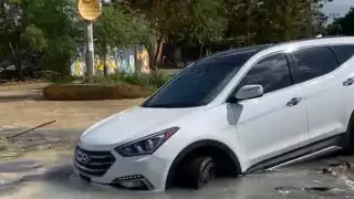 Revienta ducto de agua potable de Aguakan en Cancún y cae vehículo