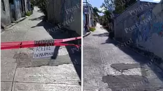 Andador cerrado por riesgo vial frente a letrero de advertencia