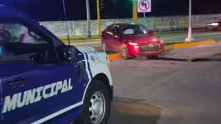 Mujer pierde el control de su automóvil y derriba anuncio municipal.