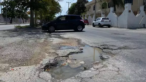 Debido a la falta de mantenimiento, el agujero en el pavimento ha crecido poco a poco Debido a la falta de mantenimiento, el agujero en el pavimento ha crecido poco a poco
